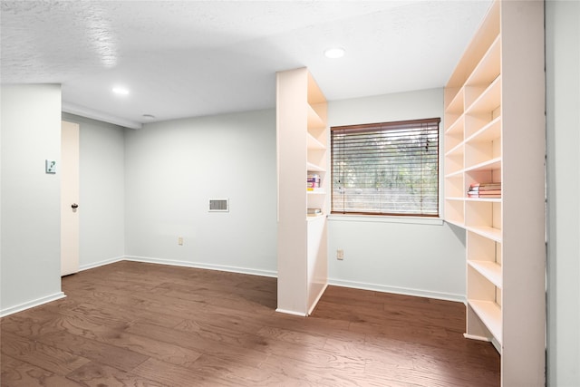 interior space with dark wood-type flooring and a textured ceiling