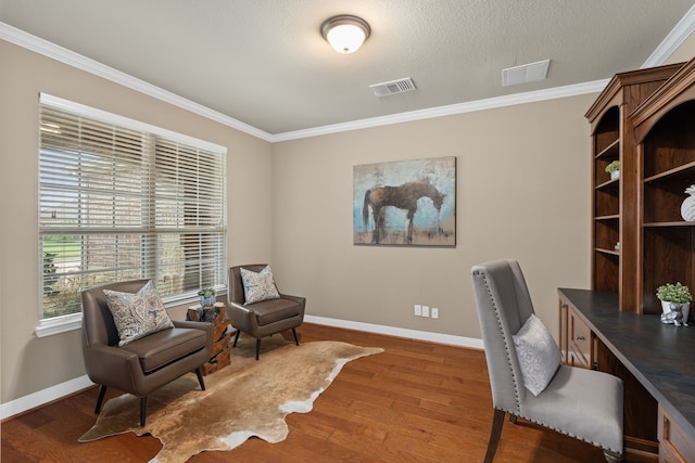 office with wood finished floors, visible vents, baseboards, and ornamental molding