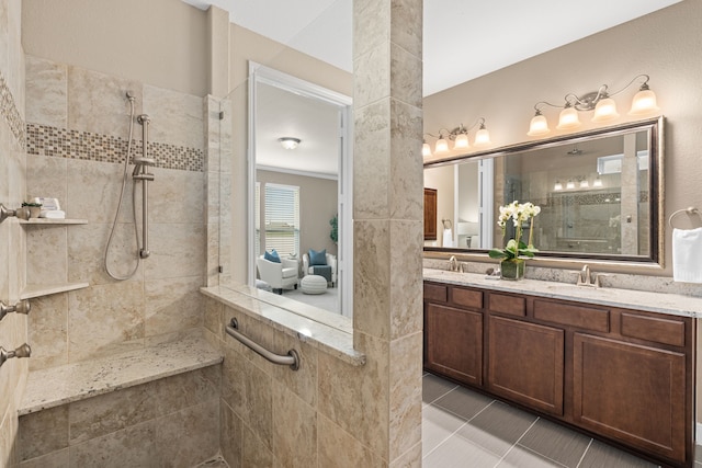bathroom featuring tile patterned flooring, walk in shower, double vanity, and a sink