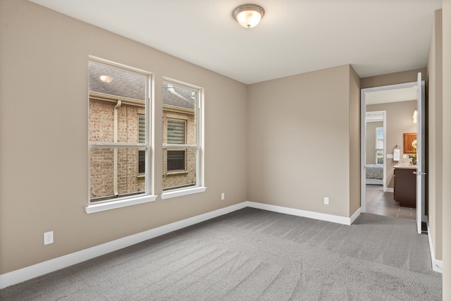 spare room featuring baseboards and carpet floors