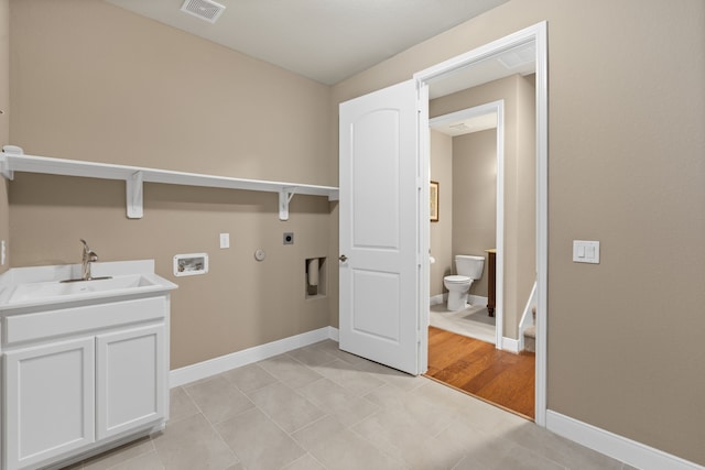washroom featuring baseboards, visible vents, a sink, hookup for an electric dryer, and laundry area
