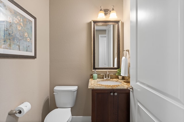 half bath featuring toilet and vanity
