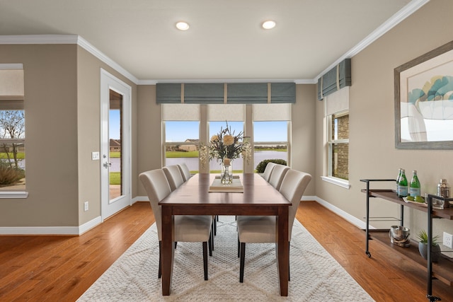 dining room with a wealth of natural light, ornamental molding, and wood finished floors