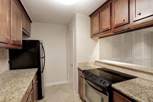 kitchen with light stone counters, decorative backsplash, and appliances with stainless steel finishes