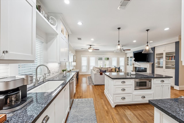 kitchen with stainless steel appliances, white cabinetry, and sink