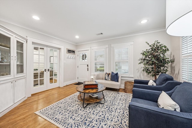 living room with crown molding, light hardwood / wood-style flooring, and french doors