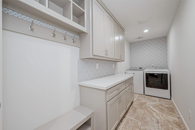 clothes washing area with cabinets and independent washer and dryer