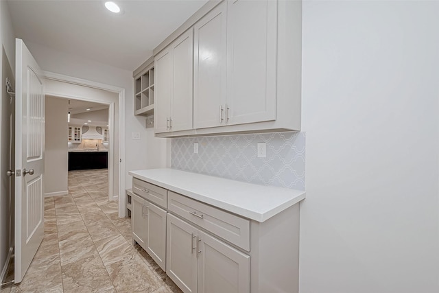 kitchen featuring tasteful backsplash and white cabinets