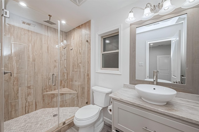 bathroom with an enclosed shower, vanity, and toilet