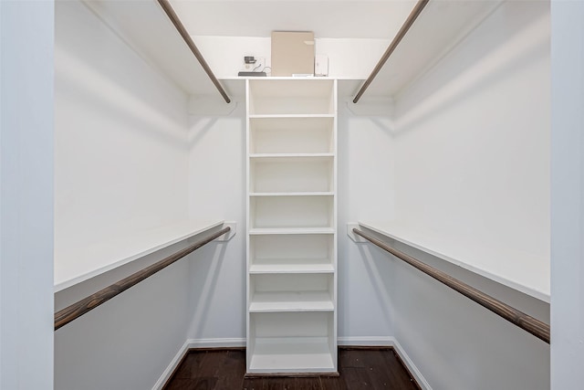 walk in closet with dark wood-type flooring