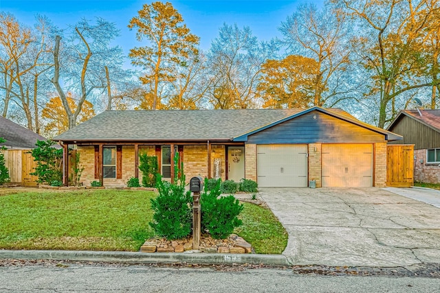 single story home with a garage and a front lawn