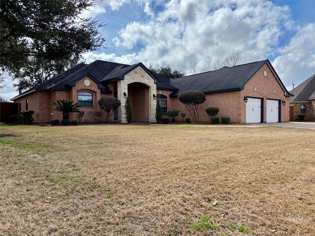 french country home with stone siding, a front lawn, and brick siding