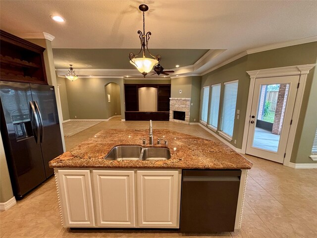 kitchen with decorative light fixtures, a kitchen island with sink, black appliances, white cabinetry, and a sink