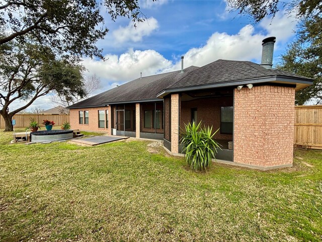 back of house with a sunroom, fence, and a yard