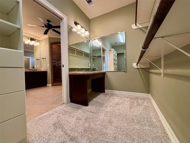 bathroom with crown molding, ceiling fan, and vanity