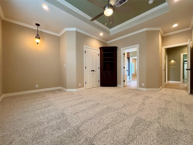 carpeted empty room with a raised ceiling, crown molding, and ceiling fan