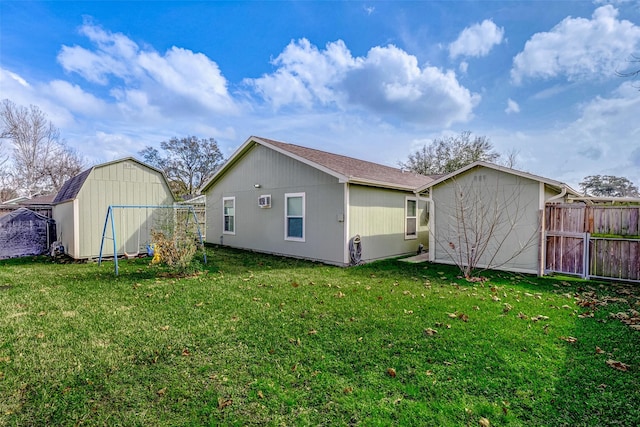 back of house with a yard and a storage unit