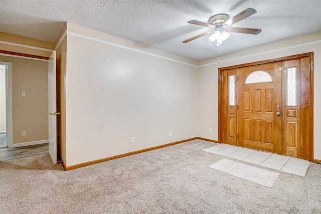 carpeted foyer entrance with ceiling fan and a textured ceiling