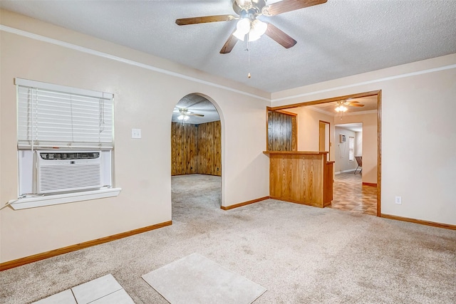 carpeted spare room with crown molding, cooling unit, ceiling fan, and a textured ceiling