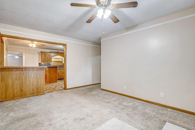 unfurnished living room with crown molding, light carpet, ceiling fan, and a textured ceiling