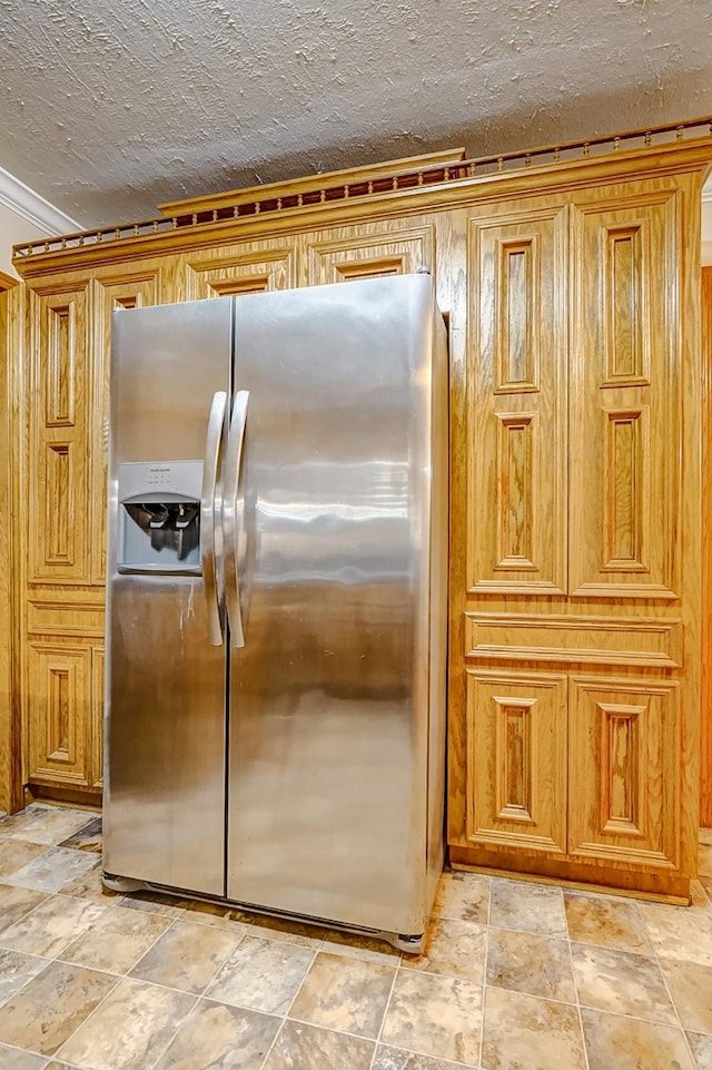 kitchen with stainless steel fridge and a textured ceiling