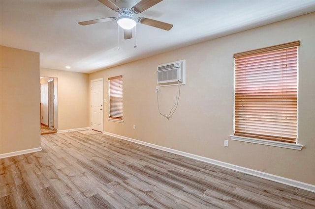 unfurnished room featuring a wall unit AC, ceiling fan, and light wood-type flooring