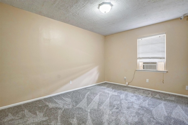 unfurnished room with cooling unit, carpet floors, and a textured ceiling