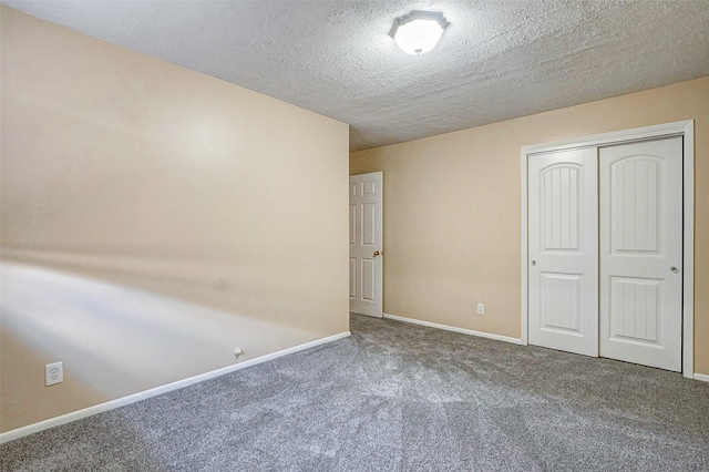 unfurnished bedroom featuring carpet, a textured ceiling, and a closet