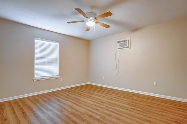 empty room with ceiling fan, a wall unit AC, and light hardwood / wood-style flooring