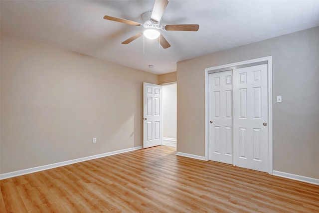 unfurnished bedroom featuring ceiling fan, a closet, and light wood-type flooring