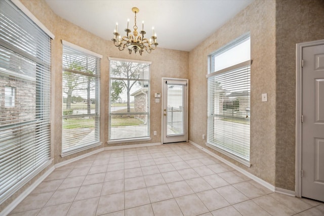 doorway featuring baseboards, an inviting chandelier, and light tile patterned floors