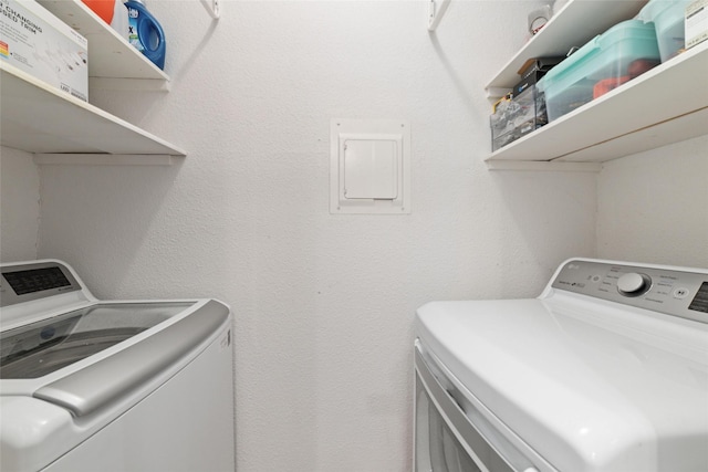 clothes washing area with electric panel and separate washer and dryer