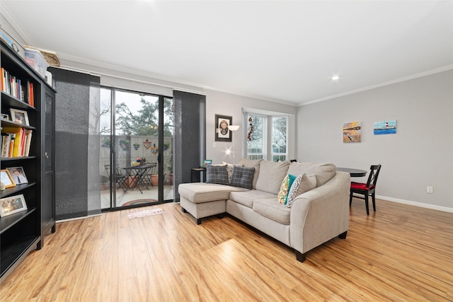 living room with ornamental molding and light hardwood / wood-style floors