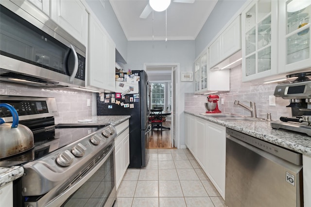 kitchen with appliances with stainless steel finishes, sink, white cabinets, and light stone counters