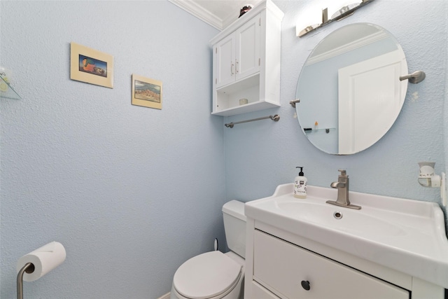 bathroom with ornamental molding, vanity, and toilet