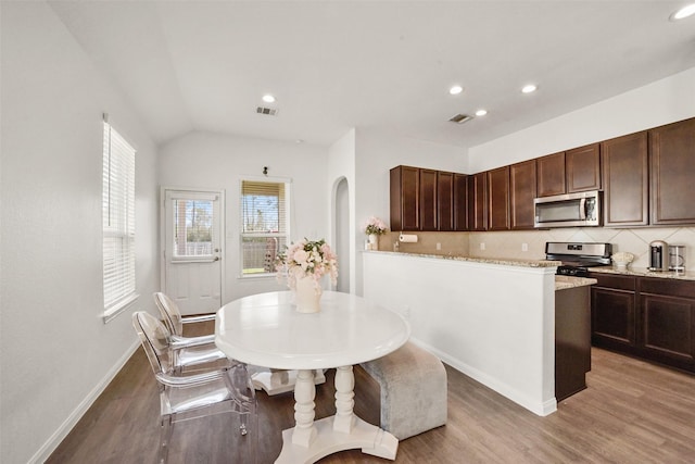 dining room featuring lofted ceiling and wood-type flooring