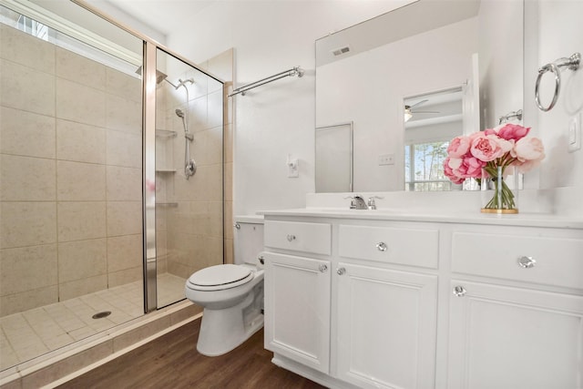 bathroom featuring vanity, toilet, an enclosed shower, and hardwood / wood-style floors