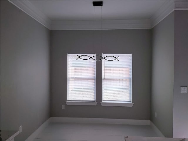 unfurnished dining area featuring ornamental molding and baseboards