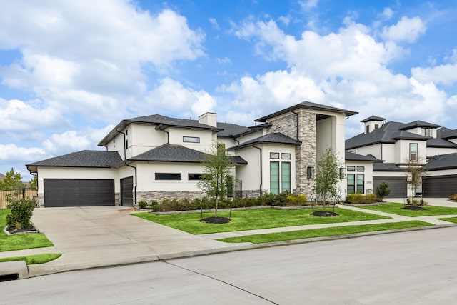 prairie-style house featuring a garage, stone siding, a front yard, and stucco siding