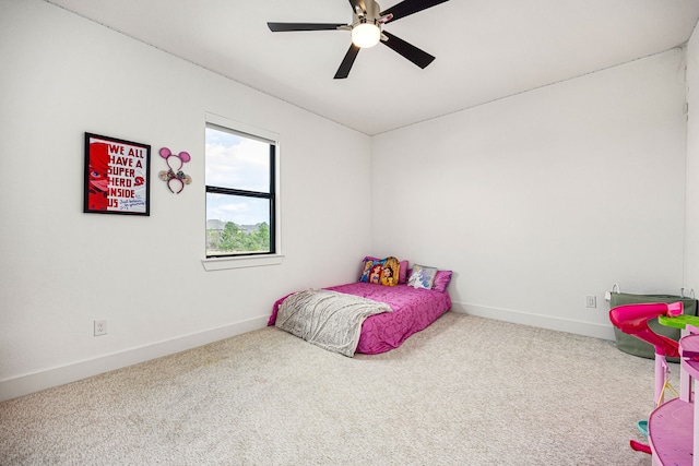 carpeted bedroom with a ceiling fan and baseboards