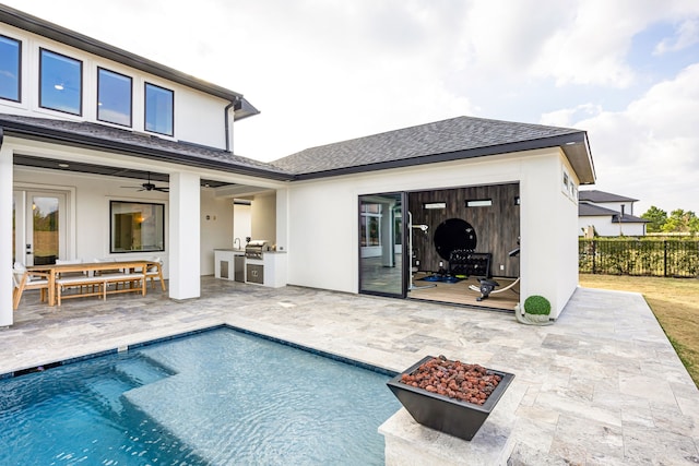 rear view of property featuring a fenced in pool, a patio, ceiling fan, fence, and exterior kitchen