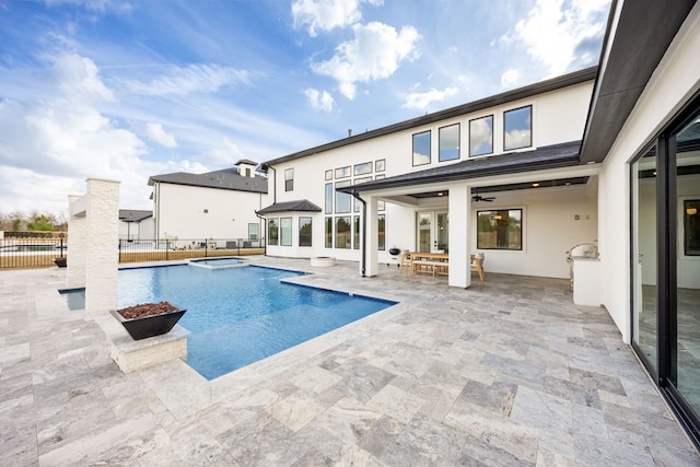 view of swimming pool with ceiling fan, a patio, fence, and a pool with connected hot tub