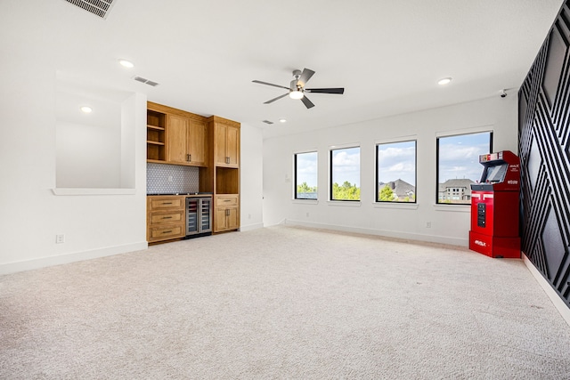 unfurnished living room featuring beverage cooler, recessed lighting, light carpet, and baseboards