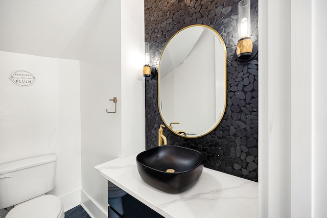 half bath with vanity, toilet, and tile patterned floors