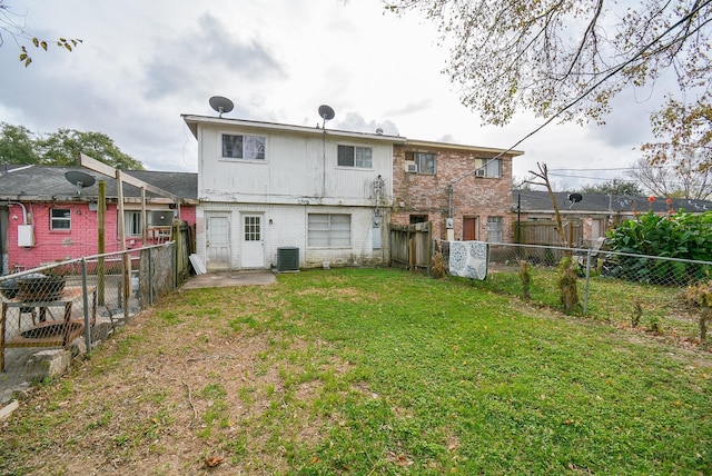 rear view of property featuring cooling unit and a yard