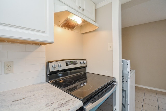 kitchen with white cabinetry, tile patterned floors, light stone counters, and stainless steel electric range