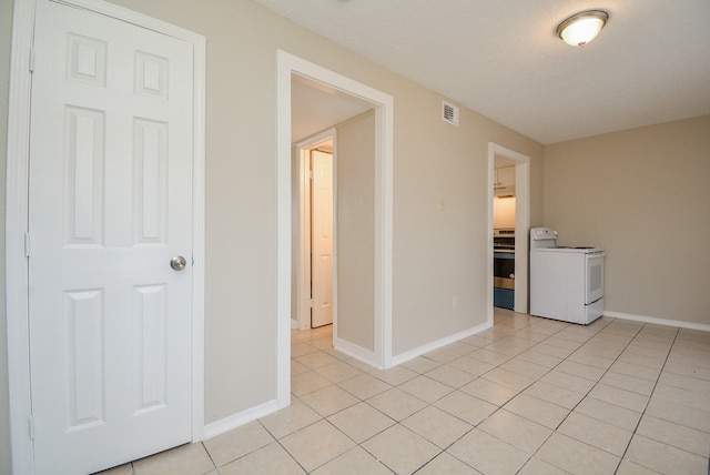 interior space featuring light tile patterned flooring and washer / dryer