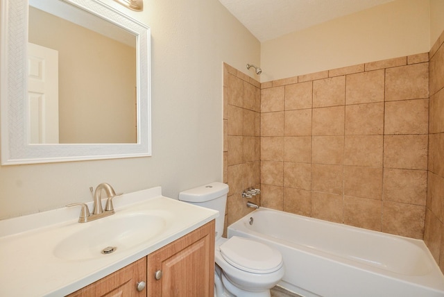 full bathroom featuring tiled shower / bath, vanity, and toilet