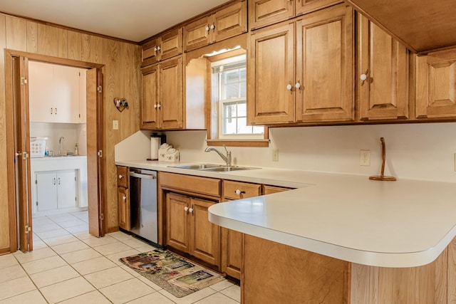 kitchen featuring sink, light tile patterned floors, wooden walls, dishwasher, and kitchen peninsula