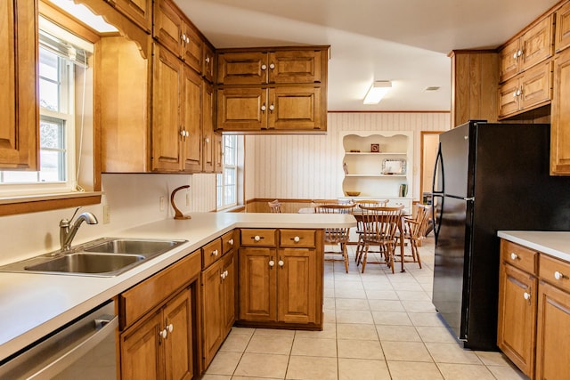 kitchen with light tile patterned flooring, dishwasher, sink, kitchen peninsula, and black fridge